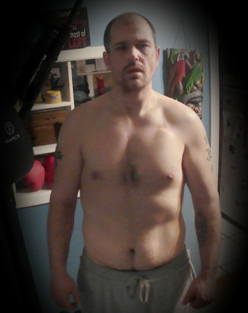 Grown man, before workout.  standing in front of a blue wall.  front view.